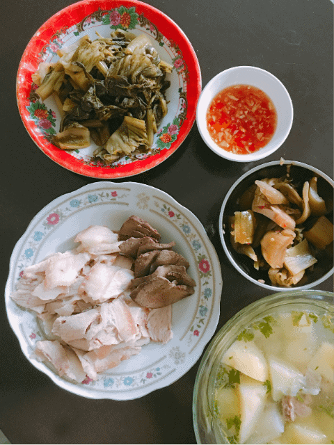 Traditional Vietnamese meal with boiled pork meat, soup, fermented cabbage